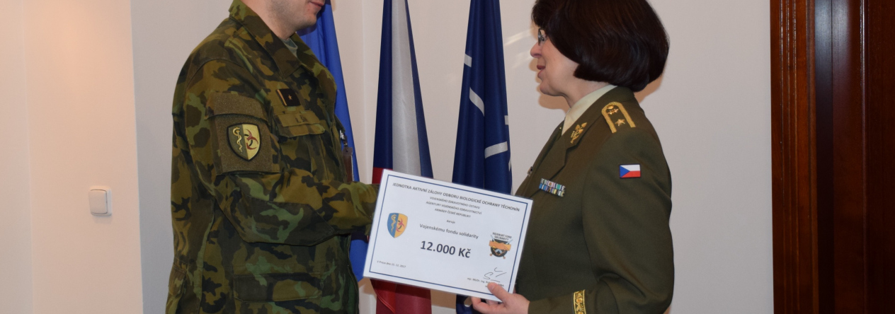 Symbolický šek převzala z rukou velitele jednotky aktivních záloh mjr. Robina Šína předsedkyně výboru Vojenského fondu solidarity brigádní generálka Lenka ŠMERDOVÁ Symbolický šek převzala z rukou velitele jednotky aktivních záloh mjr. Robina Šína předsedkyně výboru Vojenského fondu solidarity brigádní generálka Lenka ŠMERDOVÁ