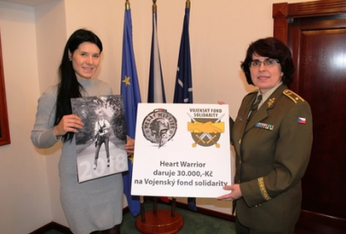 Symbolické předání šeku, Tereza Knihová (vlevo) drží v ruce kalendář, výtěžek z jeho prodeje předala Vojenskému fondu solidarity. 